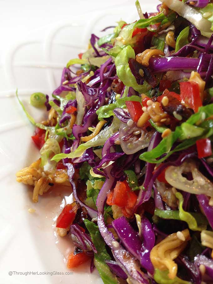 Crunchy Asian Salad with light, sweet dressing. Gorgeous salad with big crunch. Cabbage, red peppers, toasted ramen noodles, almonds and sesame seeds.