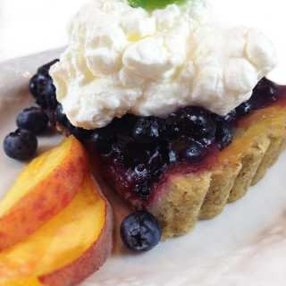Blueberry Peach Tart. Buttery pecan tart crust with luscious layers of peaches and blueberries. Garnish with fresh peaches and whipped cream.