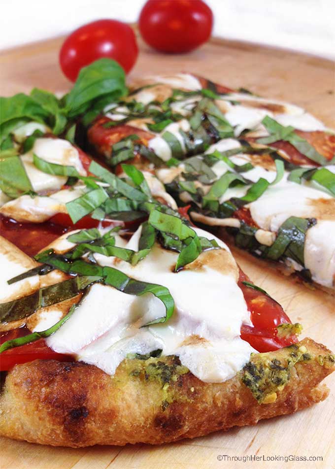 Caprese Pesto Flatbread. Fresh basil pesto, tomatoes, fresh mozzarella and drizzle of balsamic vinegar combine for a fresh & delicious flatbread pizza.