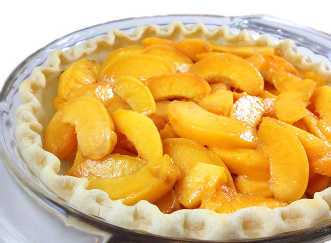 fresh sliced peaches in a pie crust to make peach pie