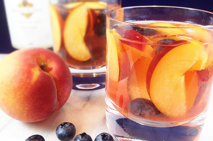 Easy and fruity: Make White Wine Peach Sangria by the pitcherful! Sweet peaches macerate in a delicious cocktail for all the pool & patio summer parties!