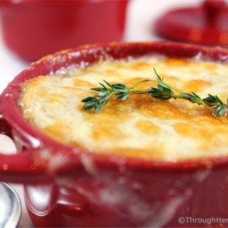 Apple Cider Caramelized Onion Soup is a sweet and flavorful version of your favorite French onion soup. Apple cider, chicken and beef broth simmer with sweet onions and thyme. Topped with a slice of French bread and bubbly sharp cheddar cheese, this is a delicious main dish or appetizer soup.