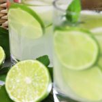 limeade in two glasses with sliced of lime and mint inside