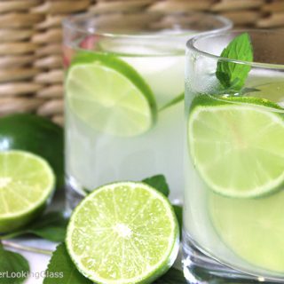 limeade in white glasses with slices of lemon inside