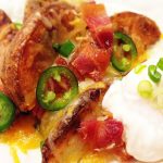 Cheesy Jalapeno Bacon Steak Fries: scrumptious appetizer or main dish. Crispy cheese smothered steak fries w/ bacon crumbles, green onions & jalapenos.