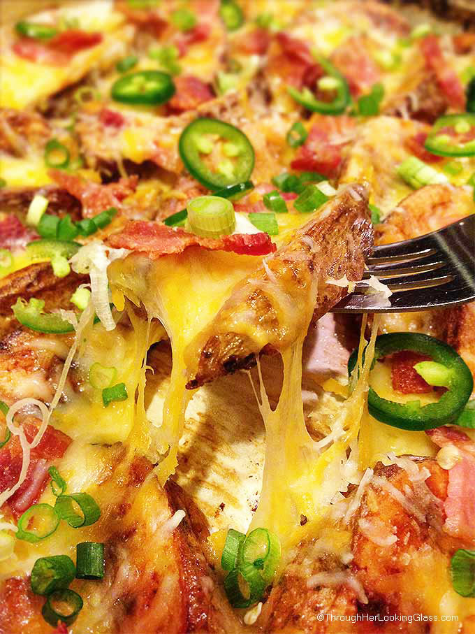 Cheesy Jalapeno Bacon Steak Fries: scrumptious appetizer or main dish. Crispy cheese smothered steak fries w/ bacon crumbles, green onions & jalapenos.