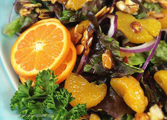 Mandarin Orange Salad: candied almonds combine w/sweet mandarins, red onion & a sweet spicy dressing for a delicious & colorful salad. This disappears fast!
