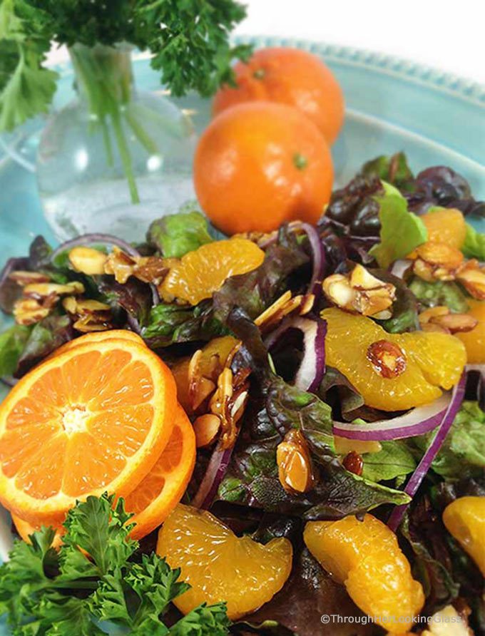 Mandarin Orange Salad: candied almonds combine w/sweet mandarins, red onion & a sweet spicy dressing for a delicious & colorful salad. This disappears fast!