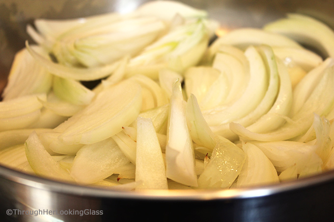 sliced white onions in a skillet to be cooked down and used to make caramelized onions