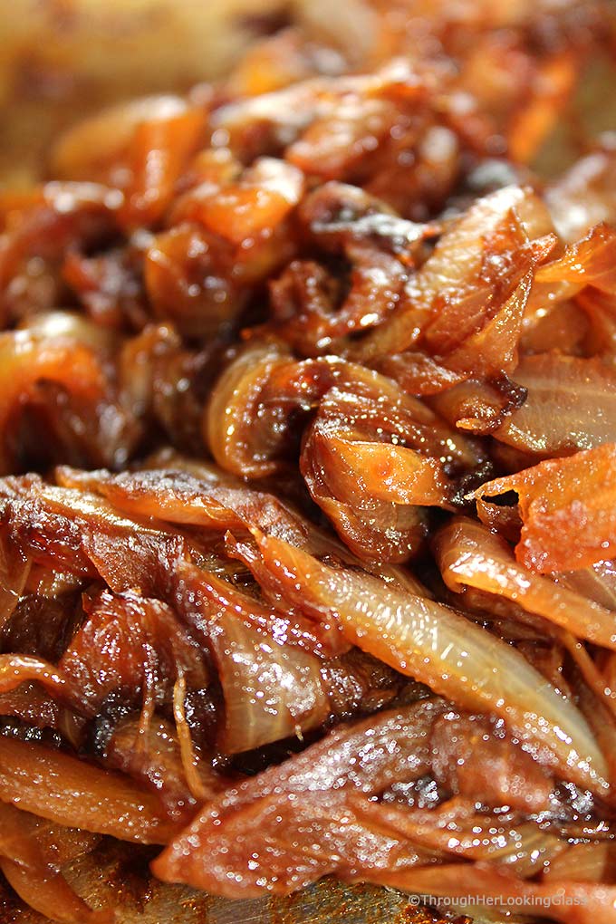 a closeup of slow-cooked golden brown caramelized onions with balsamic vinegar in a skillet