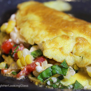 This Summer Corn Basil Tomato & Feta Easy Omelette Recipe is sure to please your friends and family for breakfast, lunch or dinner. Summer corn and juicy, ripe tomatoes combine with fresh garden basil and salty feta for a flavor-full omelette.