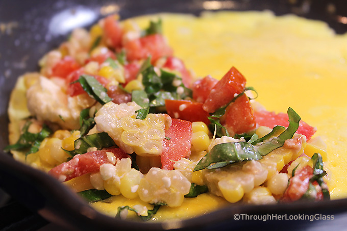 This Summer Corn Basil Tomato & Feta Easy Omelette Recipe is sure to please your friends and family for breakfast, lunch or dinner. Summer corn and juicy, ripe tomatoes combine with fresh garden basil and salty feta for a flavor-full omelette.